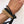 Load image into Gallery viewer, Hand wearing multiple gold and black hair ties on a white background
