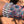 Load image into Gallery viewer, Hand wearing a beaded bracelet with a floral-patterned fabric strip on a wooden surface
