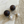 Load image into Gallery viewer, Pair of earrings with dark wooden spheres and pearl-like ends on a marble surface.

