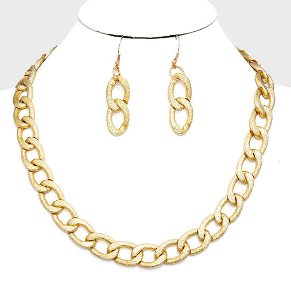 Gold-tone chain necklace and matching drop earrings displayed on a white mannequin bust against a light gray background.