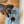 Load image into Gallery viewer, Dog standing on a striped mat with two bowls, one containing food, on a wooden floor.
