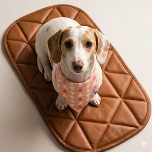 Dog wearing a pink bandana on a brown quilted mat with 'uniklook' branding.