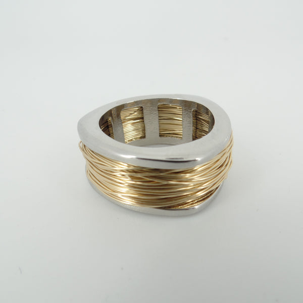 Silver and gold ring on a light gray background