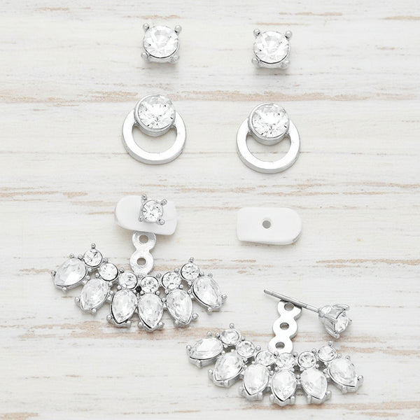 Set of silver earrings with clear gemstones on a white background