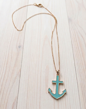 Necklace with a turquoise anchor pendant on a light wooden surface
