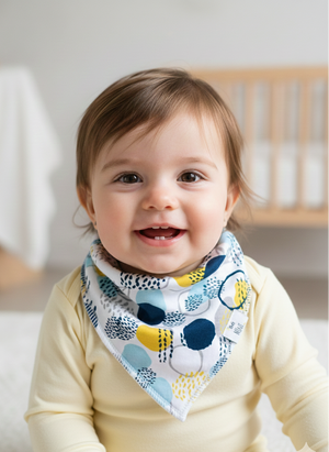 Baby wearing a colorful bib with a neutral background