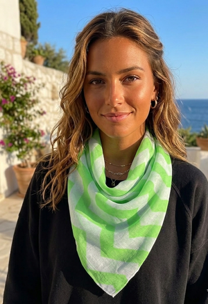 Woman wearing a green and white patterned scarf with a scenic background