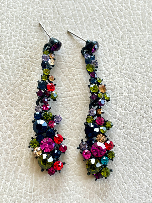 Multicolored beaded earrings on a textured white surface
