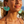 Load image into Gallery viewer, Woman wearing turquoise tassel earrings with a blurred beach background
