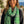 Load image into Gallery viewer, Woman wearing a green leopard print scarf with a blurred outdoor background
