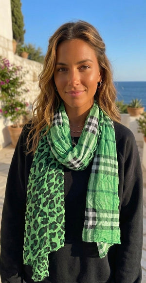 Woman wearing a green leopard print scarf with a blurred outdoor background