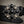Load image into Gallery viewer, A close-up of a black leather belt featuring an ornate silver-tone buckle adorned with faceted black and smoky-tinted crystals on a textured gray background.
