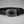 Load image into Gallery viewer, A black leather belt with a large oval silver-tone buckle featuring an engraved floral pattern and a black center, displayed on a neutral gray background.
