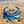 Load image into Gallery viewer, Blue beaded necklace and matching drop earrings displayed on a sandy beach with the ocean in the background.

