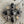 Load image into Gallery viewer, A vintage-style brooch featuring a silver-toned filigree frame with faceted dark smoky gray teardrop and oval stones, accented by smaller champagne-colored round stones, displayed on a rustic weathered wood background.
