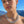 Load image into Gallery viewer, A close-up of a woman wearing a chunky silver chain necklace with a delicate silver pendant, set against a background of blue sky and distant mountains.
