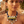 Load image into Gallery viewer, A woman wearing a chunky statement necklace with blue braided cord, white and yellow geometric beads, and clear faceted crystal drops, photographed outdoors with a warm blurred background.
