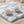 Load image into Gallery viewer, Gold and crystal stud earrings on a marble surface with sand around
