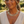 Load image into Gallery viewer, A close-up lifestyle shot of a woman wearing a chunky, woven gold chain necklace and matching drop earrings, set against a soft-focus outdoor background.

