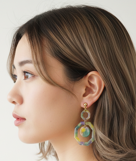 Woman wearing colorful earrings against a plain background