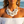 Load image into Gallery viewer, A woman at the beach wearing a chunky statement necklace made of large white disc shells and silver-toned beads, along with matching dangling earrings.

