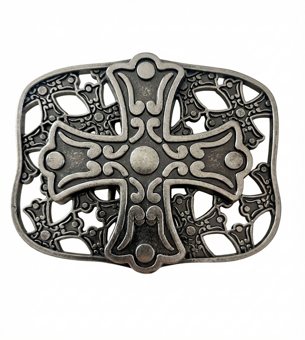 An ornate silver-toned metal belt buckle featuring a central cross motif with intricate filigree cutouts and raised decorative details, shown on a plain white background.
