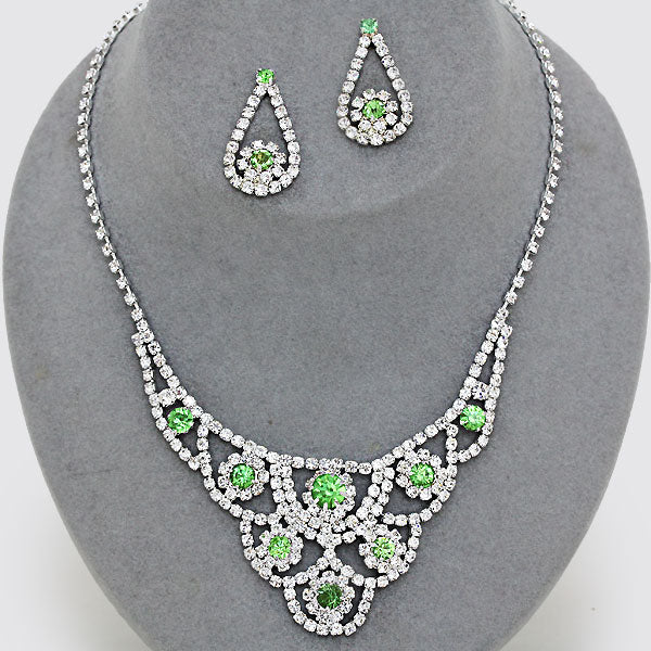 Green crystal statement necklace and matching earrings on gray display