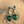Load image into Gallery viewer, Green teardrop earrings with pearl and gemstone details on a sandy background

