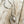 Load image into Gallery viewer, A silver-toned necklace featuring a horse head charm set within a horseshoe-shaped outline, displayed on a rustic, light-colored wooden surface.
