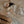 Load image into Gallery viewer, Baby lying on a bed with a striped toy, wearing a hat and holding a brown bag.
