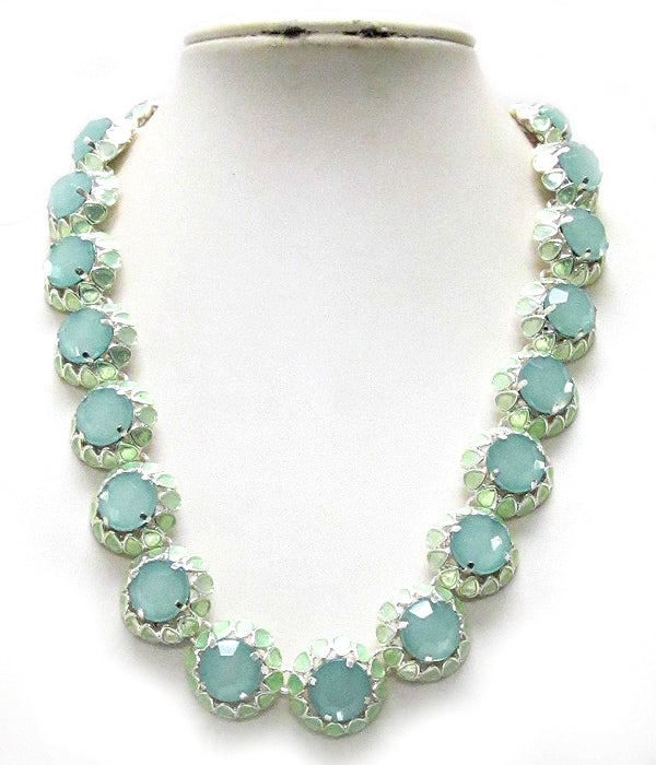 A silver-toned statement necklace featuring large, round, light aqua-green faceted gemstones in a floral cluster setting, displayed on a white neck mannequin.