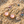 Load image into Gallery viewer, Pink earrings with gold accents on a sandy surface with seashells.
