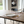 Load image into Gallery viewer, Dining table set with plates, glasses, and cutlery in a modern kitchen.

