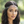 Load image into Gallery viewer, Woman wearing a decorative headpiece with a blurred green background
