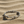 Load image into Gallery viewer, Silver bracelet with arrow designs on a sandy surface
