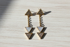 Pair of triangle-shaped earrings with gemstones on a white background