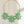 Load image into Gallery viewer, Necklace with green flower-shaped pendants on a dark surface
