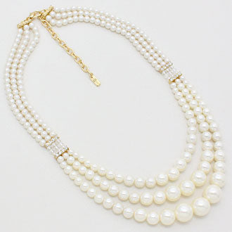 Cream three strand faux pearl necklace on white background original photo