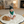 Load image into Gallery viewer, Baby sitting on a large mat with a cat, wearing green headband and bib, in a cozy living room.
