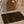 Load image into Gallery viewer, Brown diaper bag with a plush toy and a matching brown changing mat on a bed.
