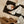 Load image into Gallery viewer, Baby lying on a black mat with a pacifier, surrounded by bags and clothes on a beige surface.
