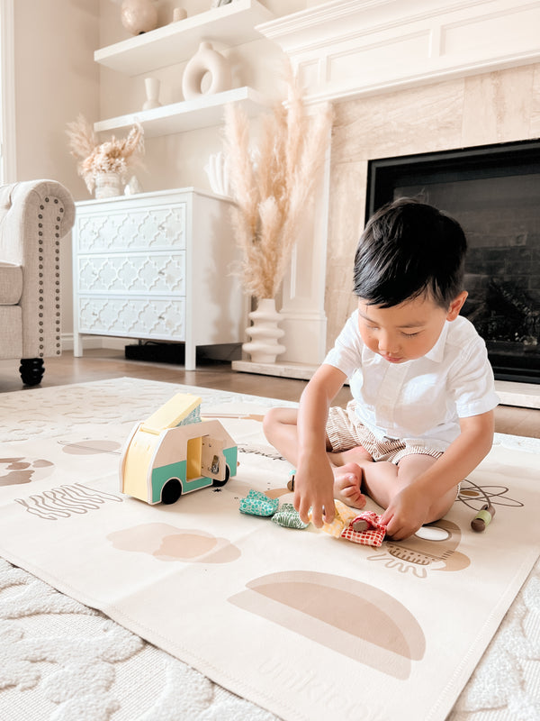 Child playing with toys on a rug in a living room.