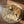 Load image into Gallery viewer, Dog playing with a bone on a round quilted mat on a wooden floor
